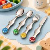 FnS Kids 4-Pc stainless steel cutlery set with colorful smiley handles, including two spoons, fork and knife on blue mat.
Copy