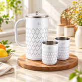 FnS Lecce 3-Pc white stainless steel water pitcher and two glasses displayed on a wooden board in a bright home kitchen.