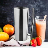 FnS Stainless Steel Water Pitcher 1.5 L with polished finish styled beside fresh fruits and a smoothie on a modern countertop.