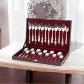 Premium cutlery set with golden chevron detailing displayed in a velvet-lined presentation box on a wooden table.