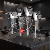 FnS Perth 24-piece stainless steel cutlery set with spoons and forks neatly arranged on a stand in a modern dark kitchen.