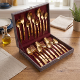 FnS Allie 18-piece rose gold stainless steel cutlery set with spoons and forks arranged in a leatherette box on a table.