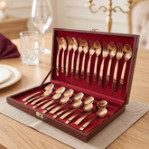 FnS Allie 24-piece rose gold cutlery set with spoons and forks arranged in a leatherette box on an elegant dining table.