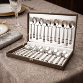 FnS Madrid 24-piece stainless steel cutlery set with textured handles displayed in a leatherette box on a dining table.