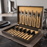 FnS Phoenix Black Finish 24 Pc cutlery set with patterned handles displayed in an open leatherette box on a dining table.