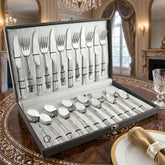 FnS Venice 24-piece stainless steel cutlery set displayed in an open leatherette box on an ornate luxury dining table.