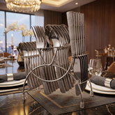 FnS Zest 24-piece stainless steel cutlery set with textured handles shown on a hanging stand on an elegant dining table.