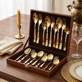 Montavo by FnS Alexa Gold 18-piece cutlery set in an open leatherette box, styled on an elegant wooden fine-dining table.