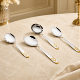 Montavo by FnS Magna 4-piece serving spoon set with silver finish and gold accents on an elegant premium dining table.