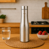 Montavo by FnS Purify 750 ml stainless steel water bottle displayed on a woven mat in a warm modern kitchen