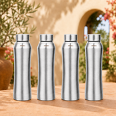 Montavo by FnS Oasis 1 litre stainless steel water bottle set of 4 with silver caps displayed on a sunlit garden table.