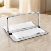 FnS Rico stainless steel napkin holder with center bar arms, polished finish and white napkins on a dining table.