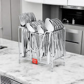 Polished stainless steel cutlery neatly organized in a metal holder on a marble kitchen counter.