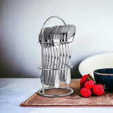 Sleek Stainlessss steel spoons and forks neatly arranged on a stand beside strawberries on table.
