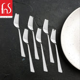 Six stainless steel dessert forks with textured handles arranged on dark slate surface
