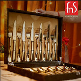 Elegant gold cutlery set neatly arranged in open black case with fnS Premium Dining branding.