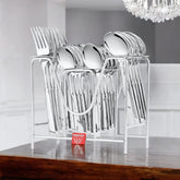 Full silver cutlery set in metal rack placed on polished wooden table under chandelier in dining room.