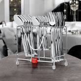 Stainless steel cutlery neatly arranged in a sleek metal stand, displayed on a wooden table.