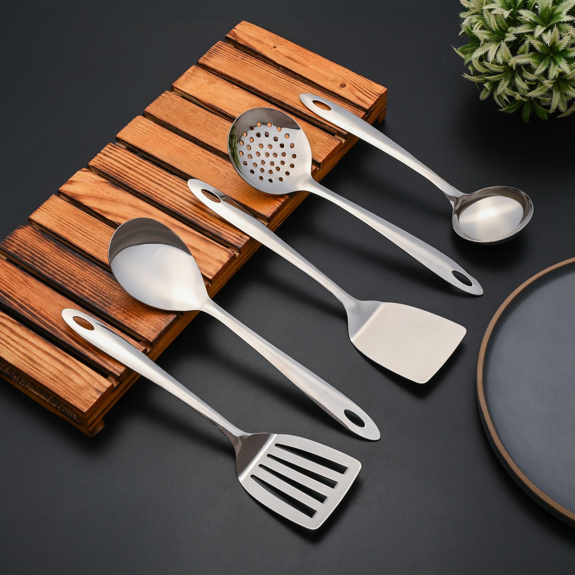 Montavo cooking spoon, turner, and kitchen gadgets arranged on bamboo rest with dark background display.