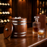 FnS wooden finish stainless steel ice bucket with lid and ice cubes, displayed on a bar counter with blurred glassware.