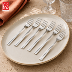 Montavo by FnS Nile 12-piece stainless steel dessert fork set with single-line handles displayed on an elegant plate.
