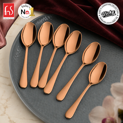 Six Livo rose gold stainless steel baby spoons with mirror finish arranged on a premium hammered grey plate from FnS.
