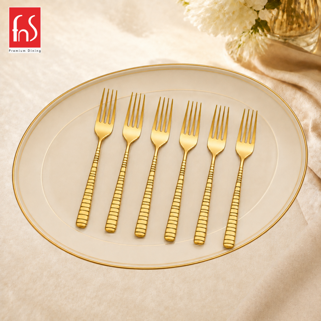 FnS Boston 6 Pcs Stainless Steel Gold Dessert Fork set with grooved handles, arranged on an elegant cream serving plate.