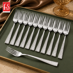 Montavo by FnS Helios 12-piece stainless steel dessert fork set with hammered handles arranged on a premium green tray.
