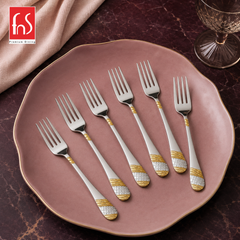 FnS Imperio 6-piece stainless steel dinner fork set with 24K gold-plated accents arranged on a large elegant pink plate.
