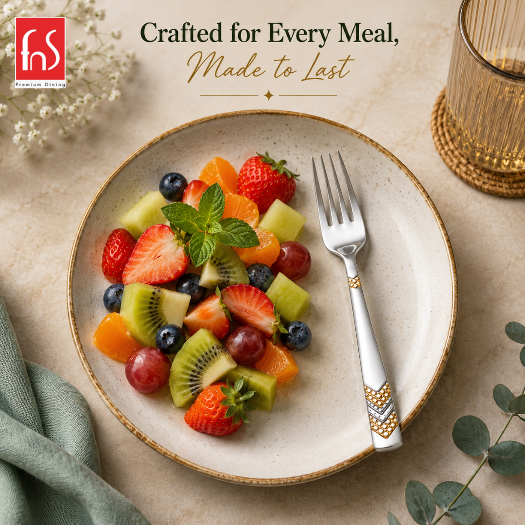 FnS RAGA 24K gold plated stainless steel fruit fork served beside fresh mixed fruits in an elegant premium table setting
