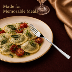 Montavo by FnS Creta stainless steel dinner fork with wavy handle served beside ravioli and roasted tomatoes on a plate.
