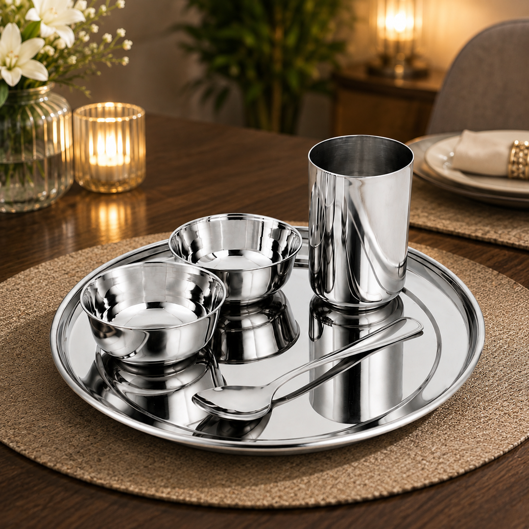 FnS Plain 5 Pcs Dinner Thali Set with stainless steel thali, two bowls, glass and spoon arranged on a wooden dining table.