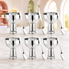 Alt Text: FnS Basil Stainless Steel Bowls Set of 6 in silver finish with six pedestal bowls and matching spoons on a marble table.