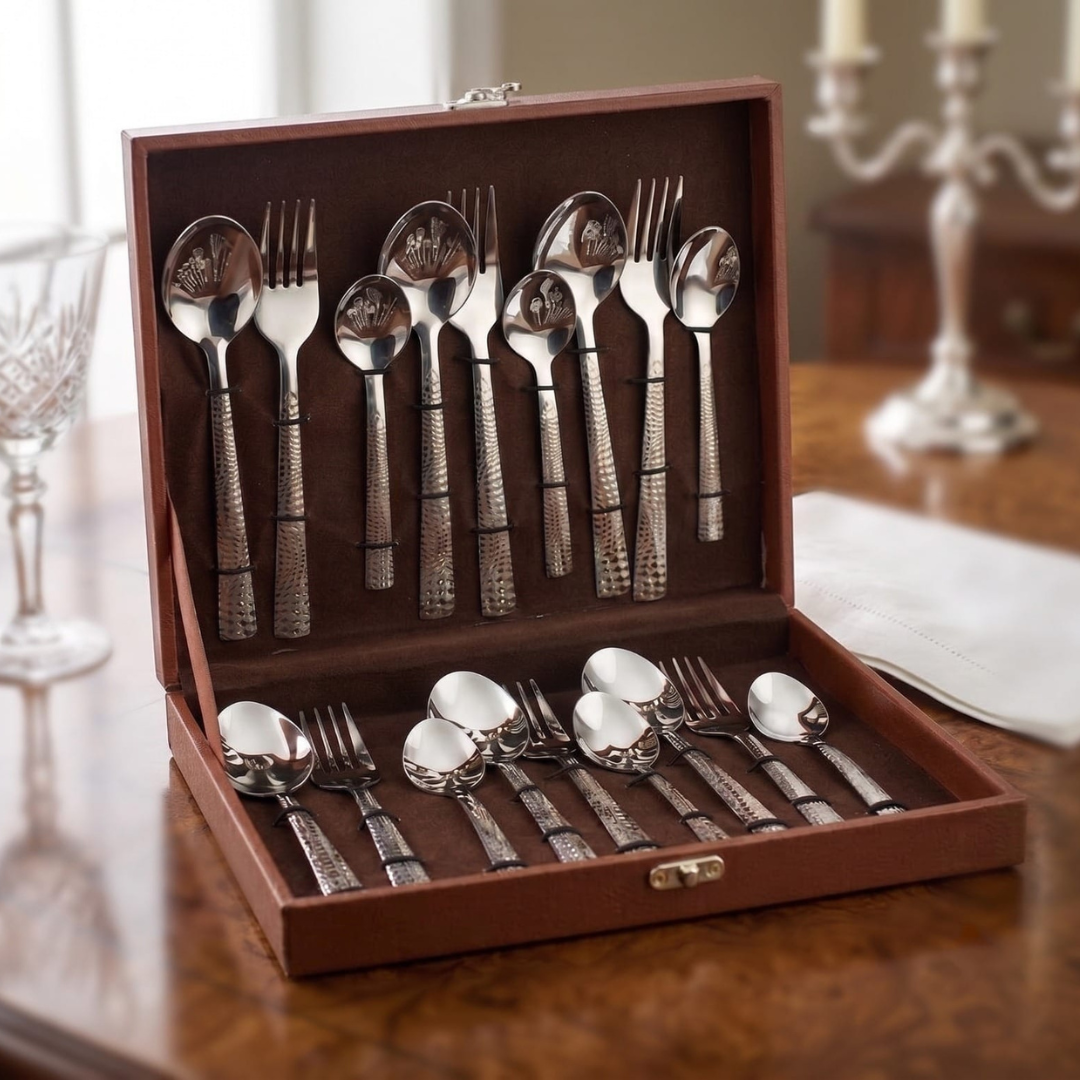 Montavo by FnS Lush 18 Pc laser engraved cutlery set arranged in an open leatherette box on an elegant wood dining table.
