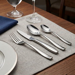 FNS Beau stainless steel cutlery set with dinner fork, knife, tablespoon, and teaspoon arranged on an elegant dining table.