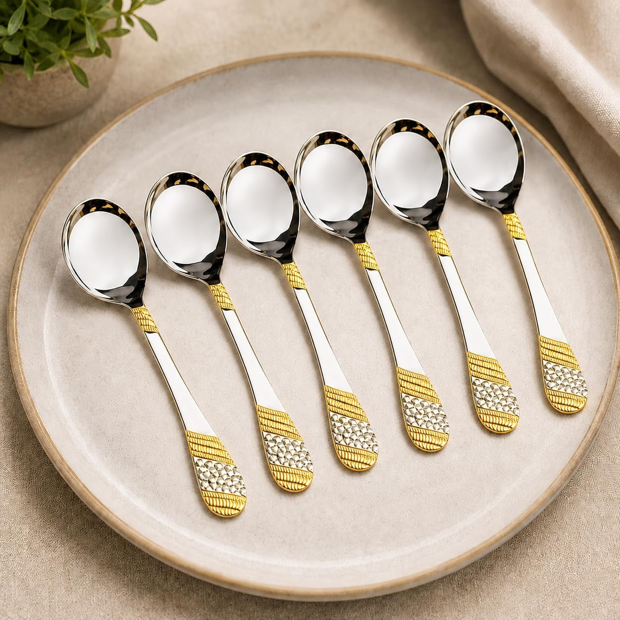FnS Imperio 6-piece 24K gold-plated stainless steel soup spoon set elegantly arranged on a premium beige serving plate.