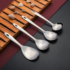 Amazon serving spoons arranged diagonally on wooden tray with decorative shells and natural elements, highlighting premium stainless steel quality and modern styling.