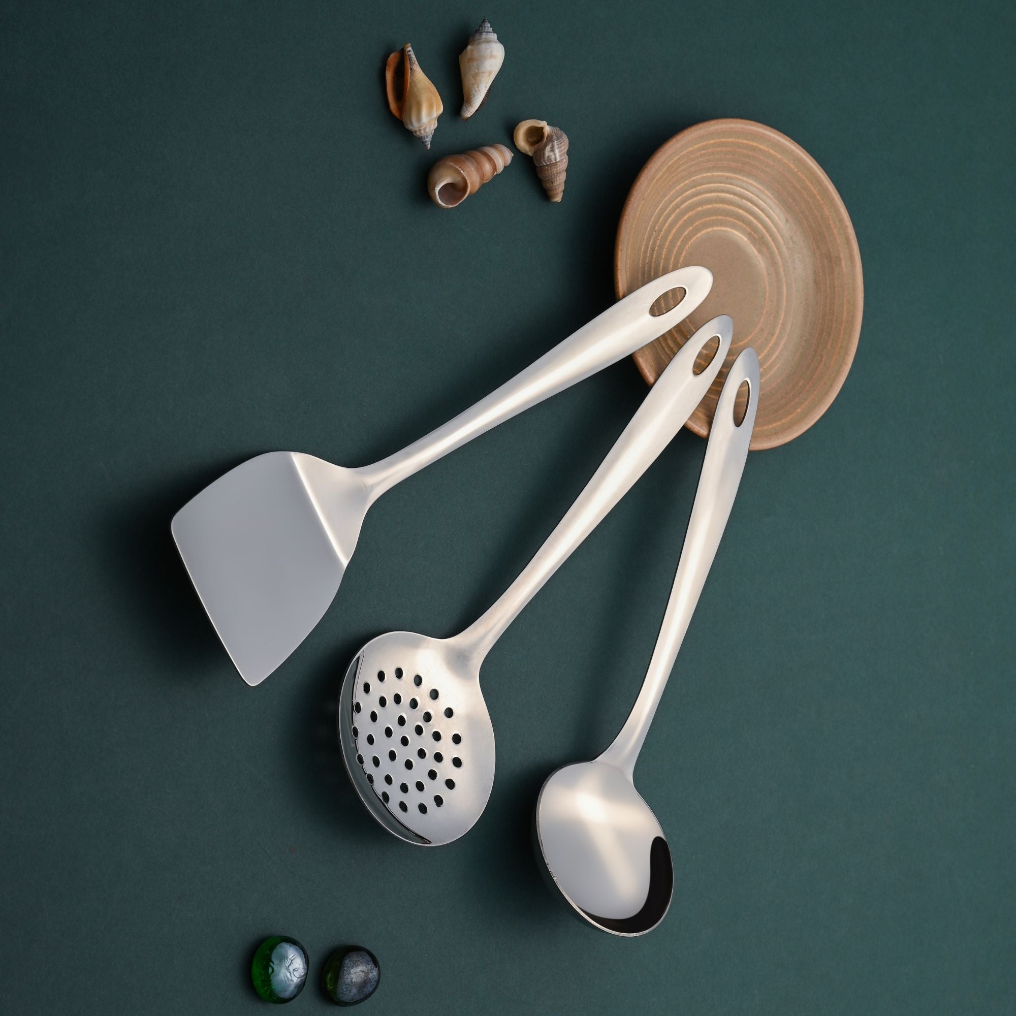 Amazon 3-piece serving utensils arranged on teal background with wooden bowl and seashell accents