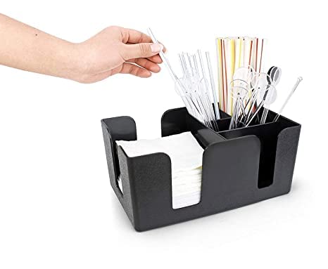 Hand reaching for straw from black bar caddy filled with napkins, straws, and bar utensils on white background