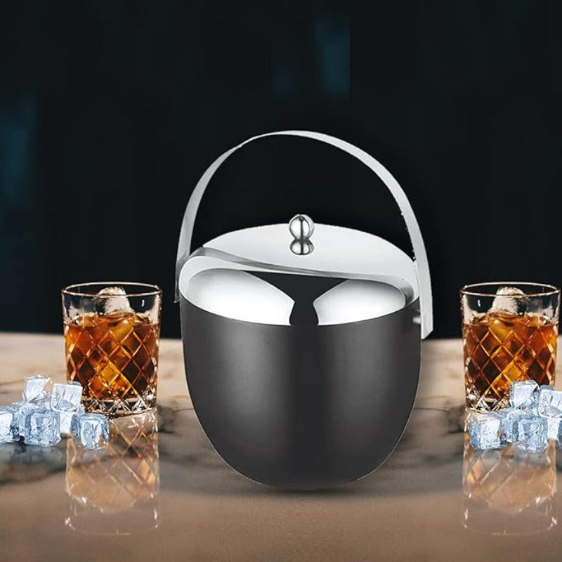 Black stainless steel ice bucket with mirror finish lid and handle, displayed with two whiskey glasses filled with ice and amber liquid on wooden surface
