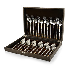Luxurious cutlery set with gold-silver detailing displayed in a brown velvet-lined presentation case.