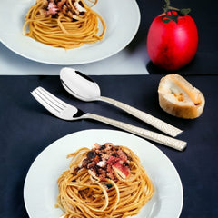 Elegant silver fork and spoon placed beside a spaghetti dish, bread roll, and decorative apple.