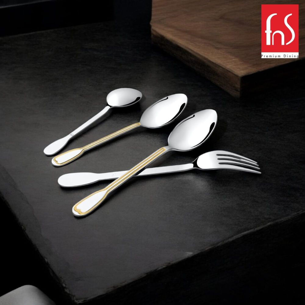 Premium gold-accented cutlery set laid on dark tabletop, highlighted with FnS logo in corner.
