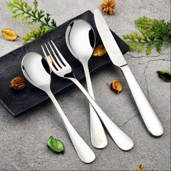Elegant stainless steel cutlery set with knife, fork, and spoons on black plate and stone background.
