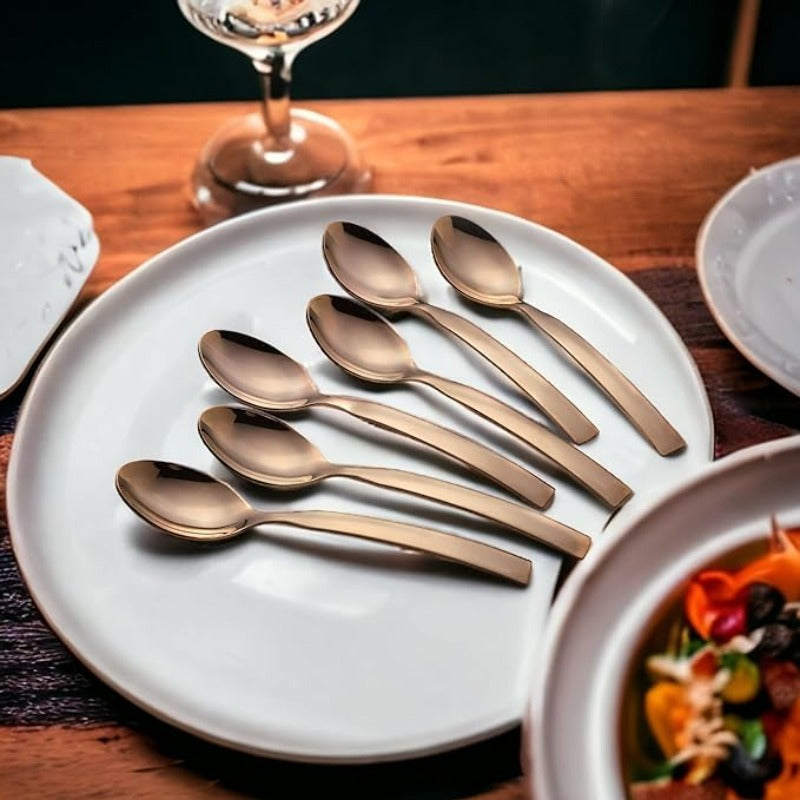 FNS Allie 6-piece rose gold dinner spoon set displayed on white plate with elegant table setting, premium stainless steel cutlery collection.
