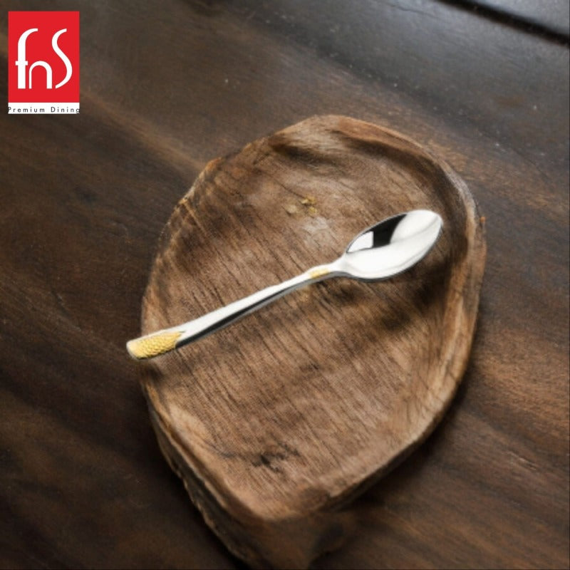 FNS August 24-karat gold plated baby spoon with textured handle displayed on rustic wooden bowl, premium infant feeding utensil for safe dining.