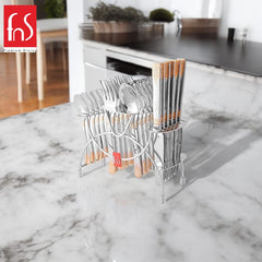 Stylish cutlery set in stand placed on marble kitchen counter, with modern dining space in background.