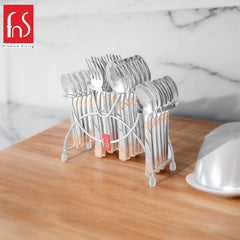 FnS stainless steel cutlery set with gold design placed on a wooden counter in modern kitchen.