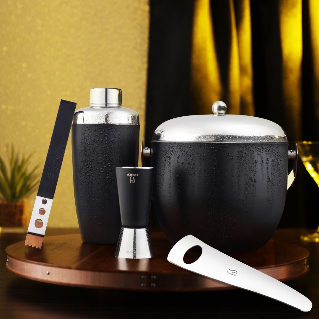 FNS 5-piece black bar tool set lifestyle shot with water droplets on copper tray with gold and black decor