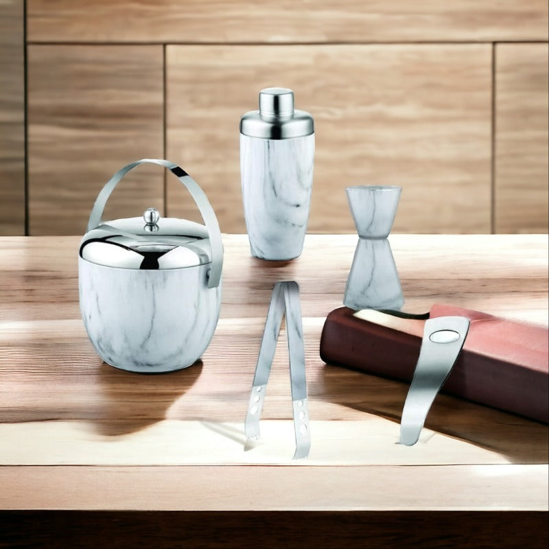 FNS 5-piece bar tool set with marble finish and stainless steel accents displayed on wooden table with brown book